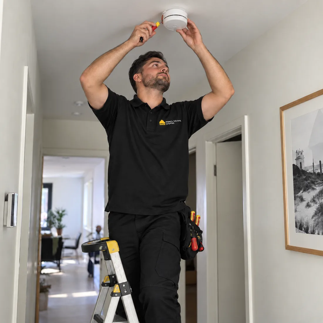 MYLO technician servicing a smoke alarm in a Queensland property